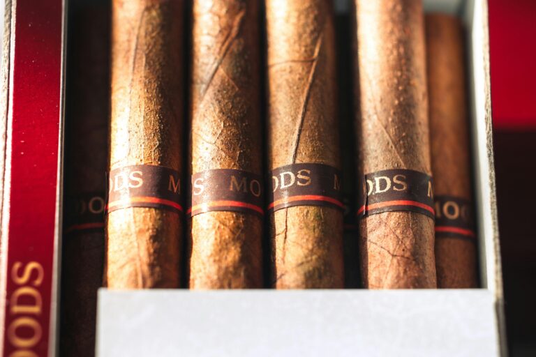 Box of Moods cigars with dark bands and red stripe, arranged side by side in a red-lined wooden box.